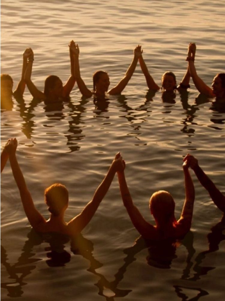 Vrouwen in het water bij zonsondergang