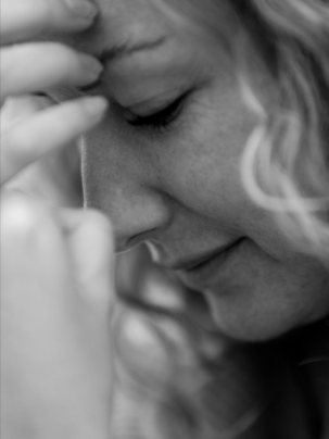 Vrouw met de hand tegen haar voorhoofd